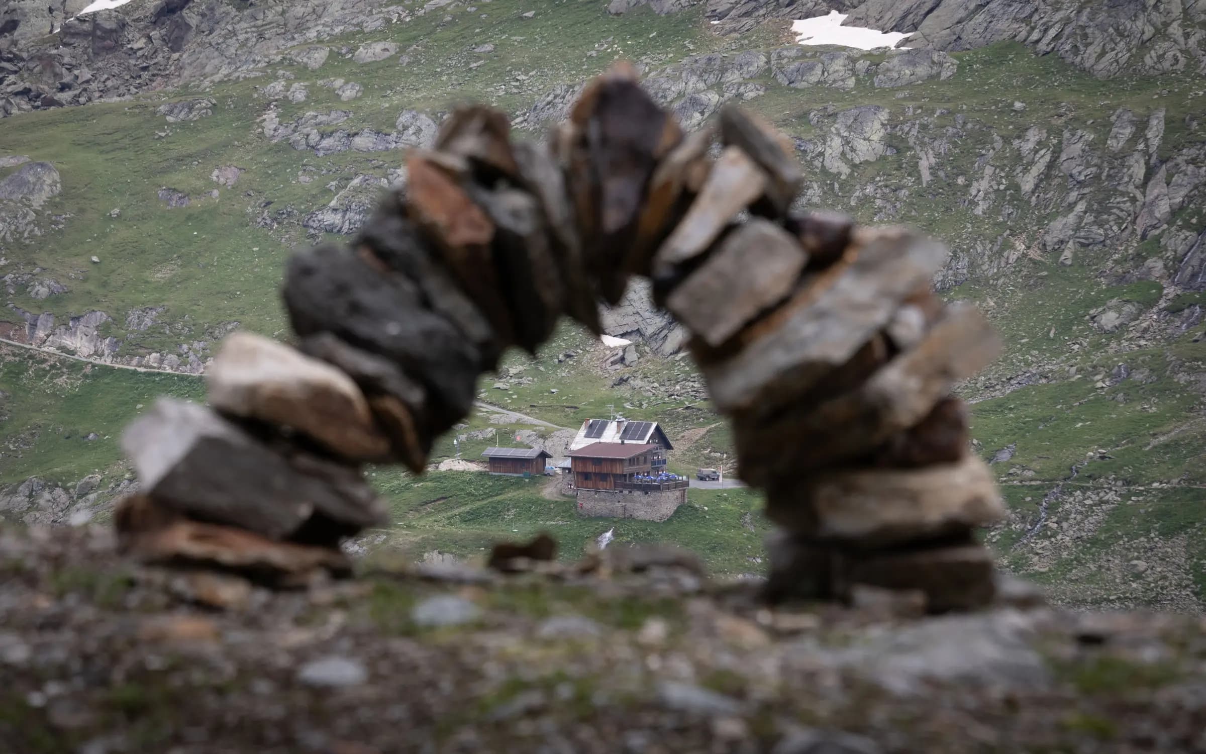 Scenic view of a mountain lodge in Obergurgl, framed by a stone arch, showcasing natural beauty.