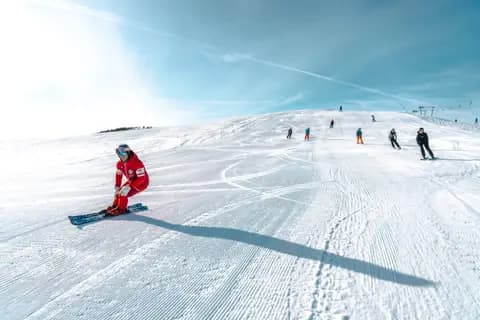 Skiers enjoy a bright winter day on the snowy slopes of Lombardia, Italy.