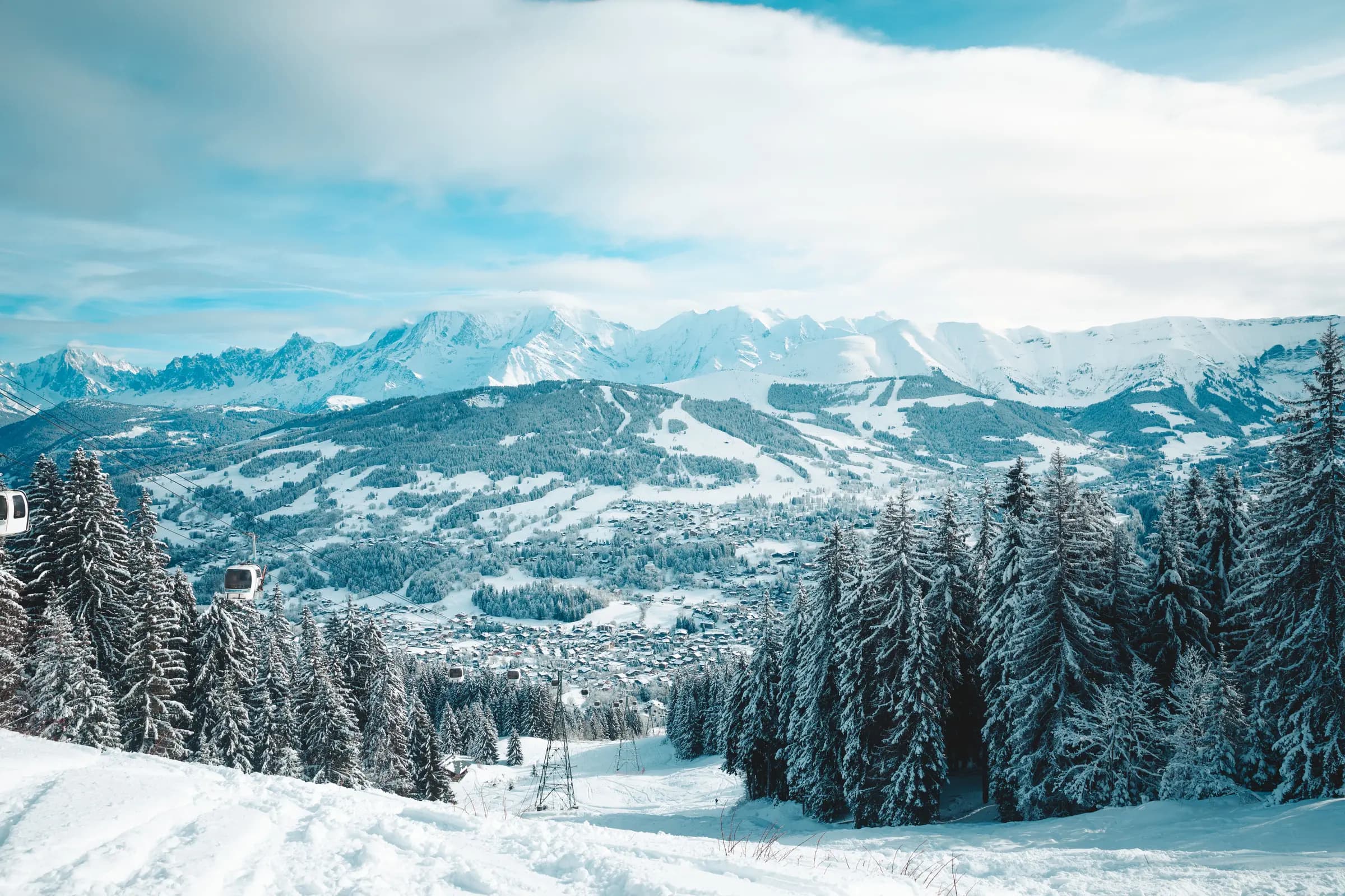 Captivating winter landscape of Megève, France, showcasing snow-covered mountains and a peaceful forest.