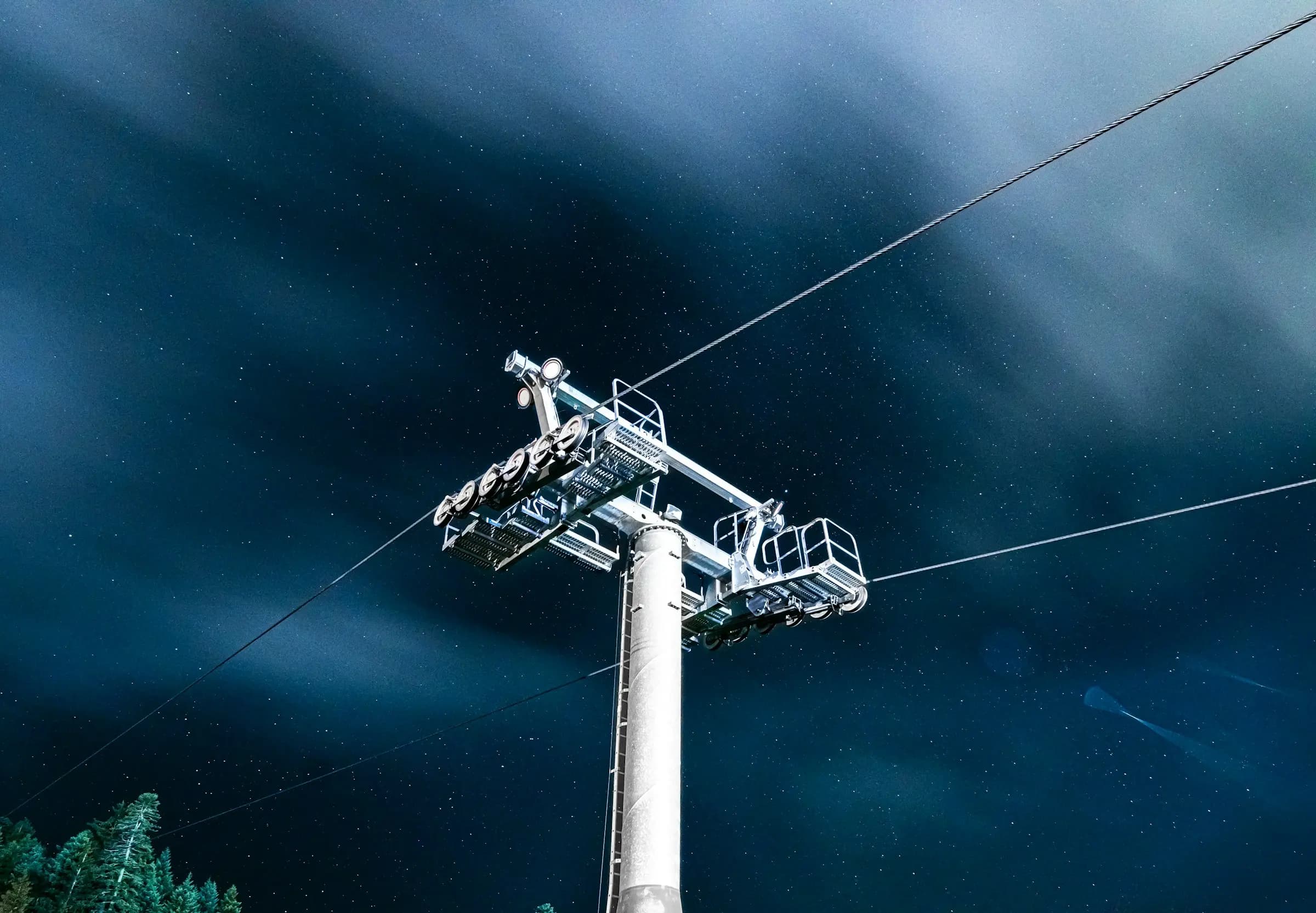 a ski lift going up a mountain under a cloudy sky