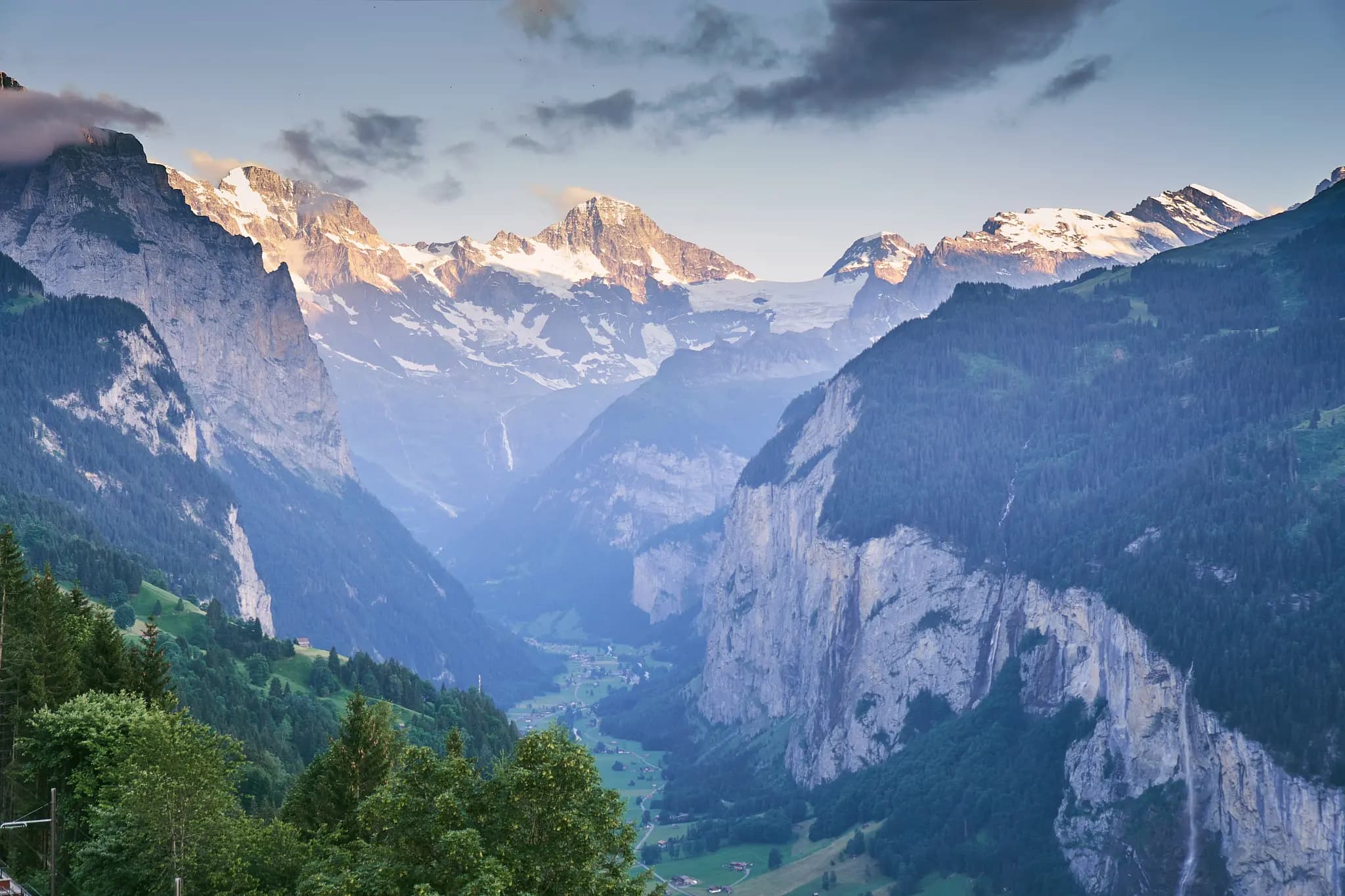 500px provided description: Taken from Wengen, The mountain peaks lit by evening light. The valley below is surrounded by all these mountains. The landscape also dotted my multiple small waterfalls. First landscape with a 35 mm lens. Happy with it. [#sunset ,#switzerland ,#mountains ,#nature ,#travel ,#clouds ,#europe ,#twilight ,#snow ,#mountain ,#valley ,#cloud ,#peak ,#alps ,#alpinism ,#outdoors ,#mountaineering ,#hiking ,#summit ,#scenic ,#alpine ,#mountain pass ,#alp ,#mountainscape ,#mountainside ,#lauterbrunnen ,#wengen ,#snowpeak]