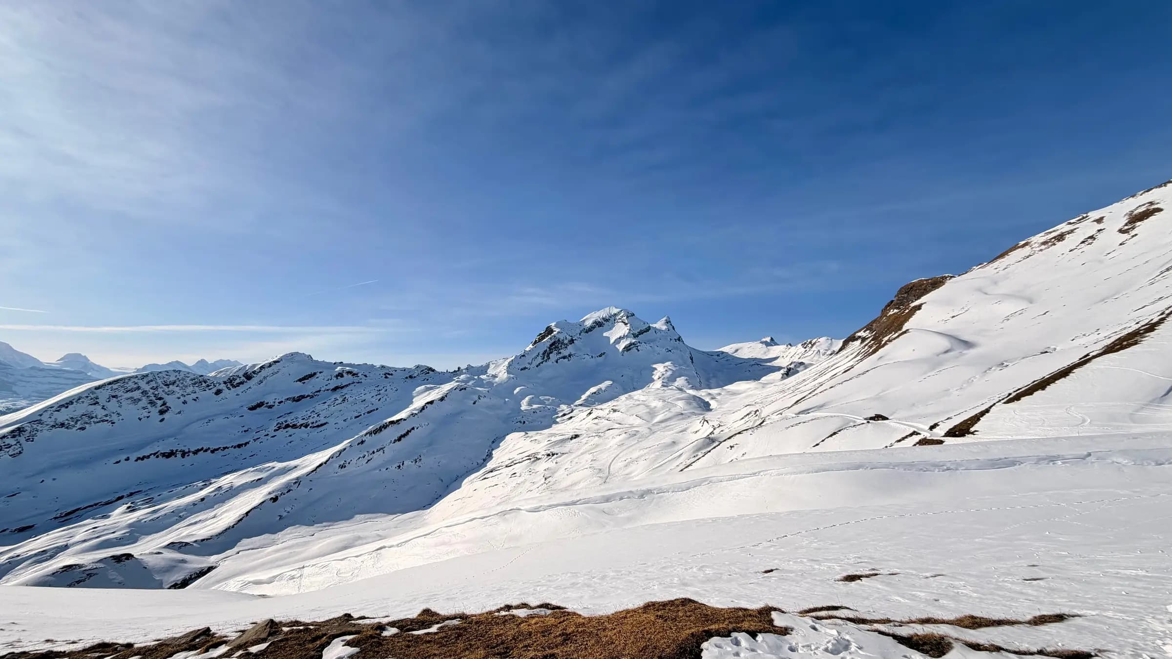 Breathtaking view of snow-covered mountains in Grindelwald, Switzerland, under a clear blue sky.