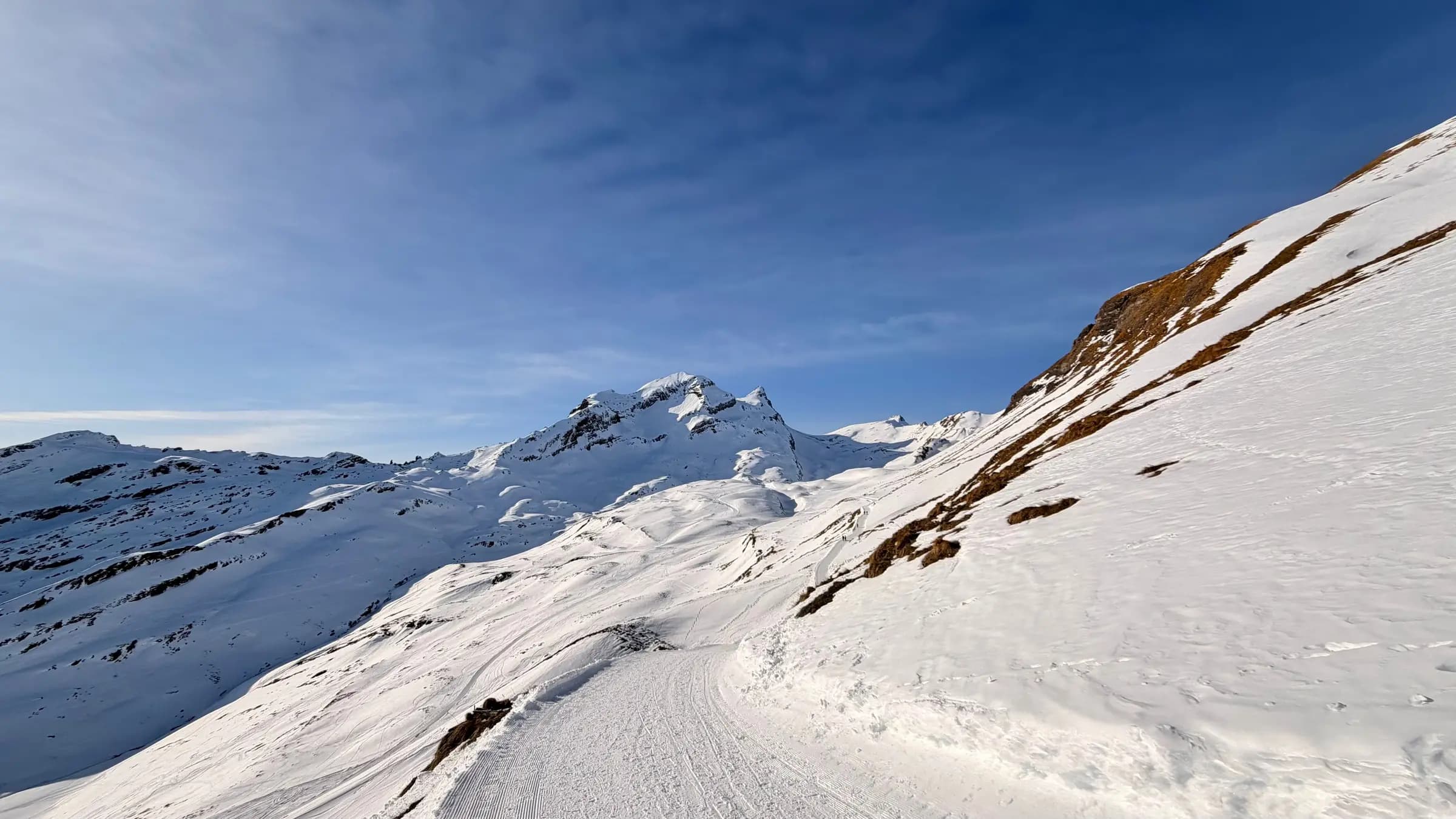Idyllic snowy mountain landscape in Grindelwald, Switzerland with clear blue skies.