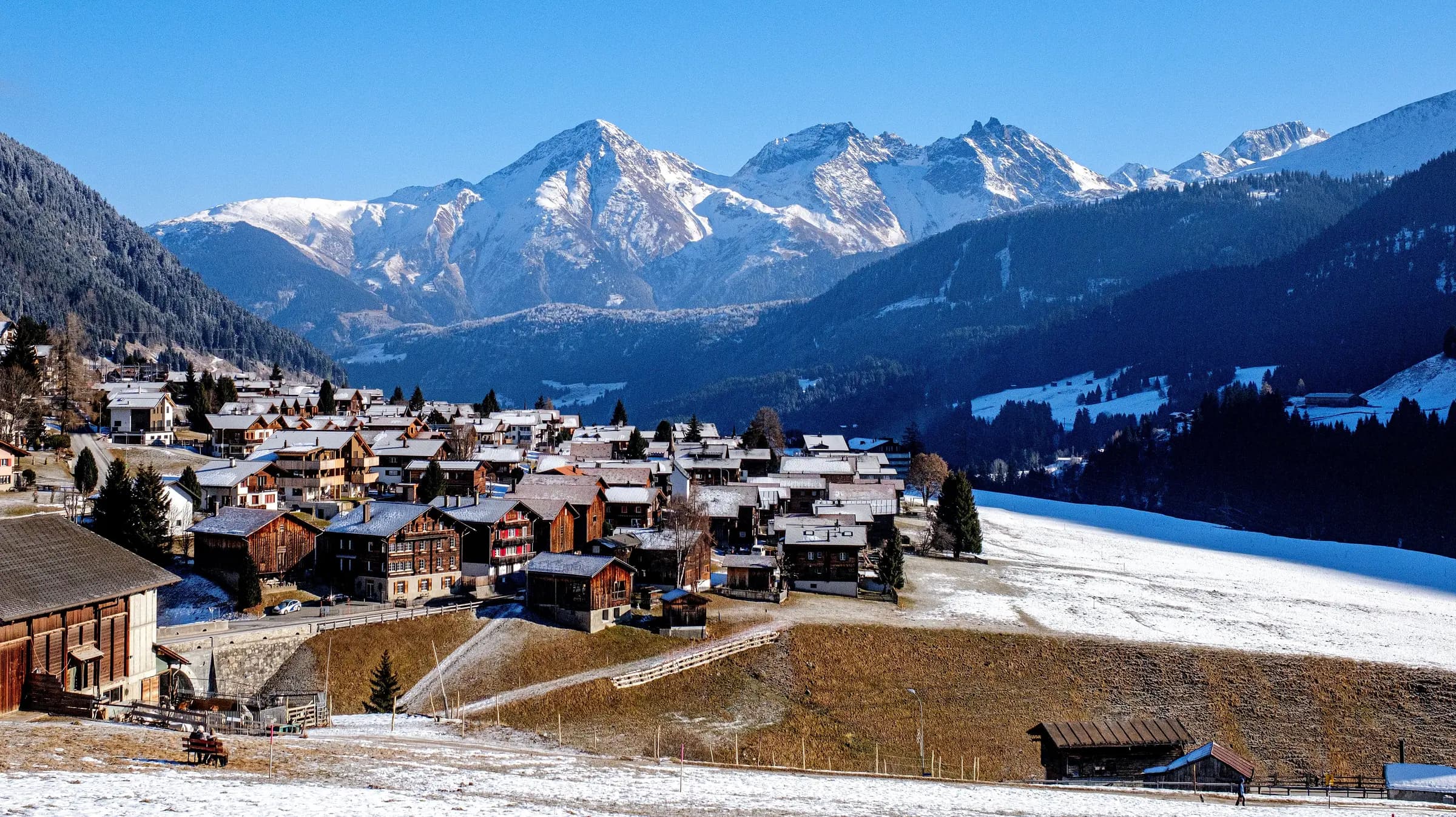 Picturesque Swiss village nestled in snow-capped Alps with stunning winter scenery.