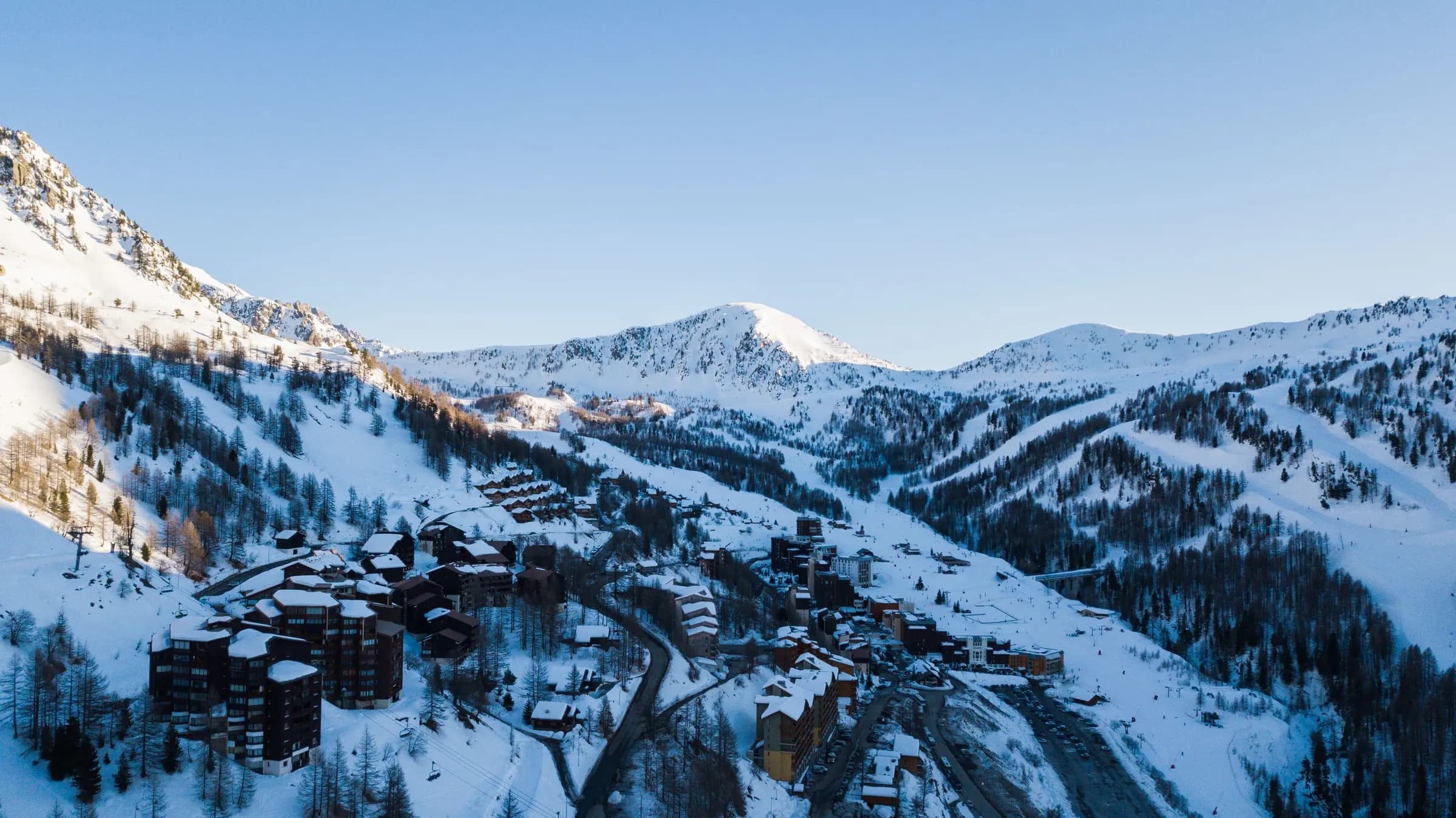 Aerial view of a picturesque snowy mountain resort village in winter.