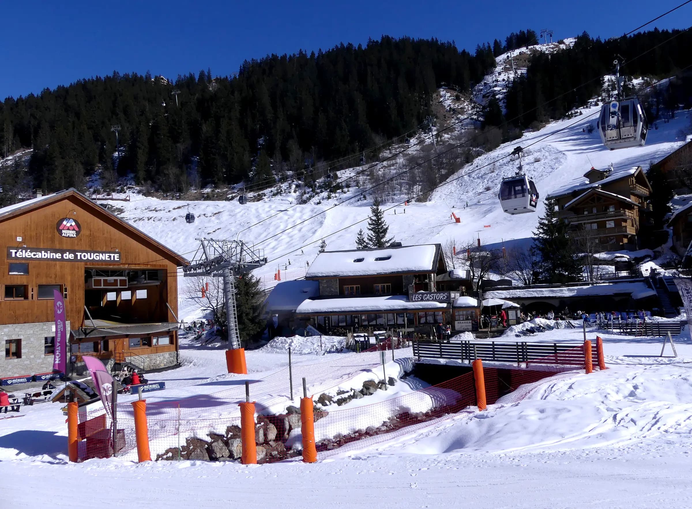 Sight, in winter, of Doron des Allues river and the departure station of Tougnète gondola lift, in Méribel-Centre village and resort, in Savoie , France .