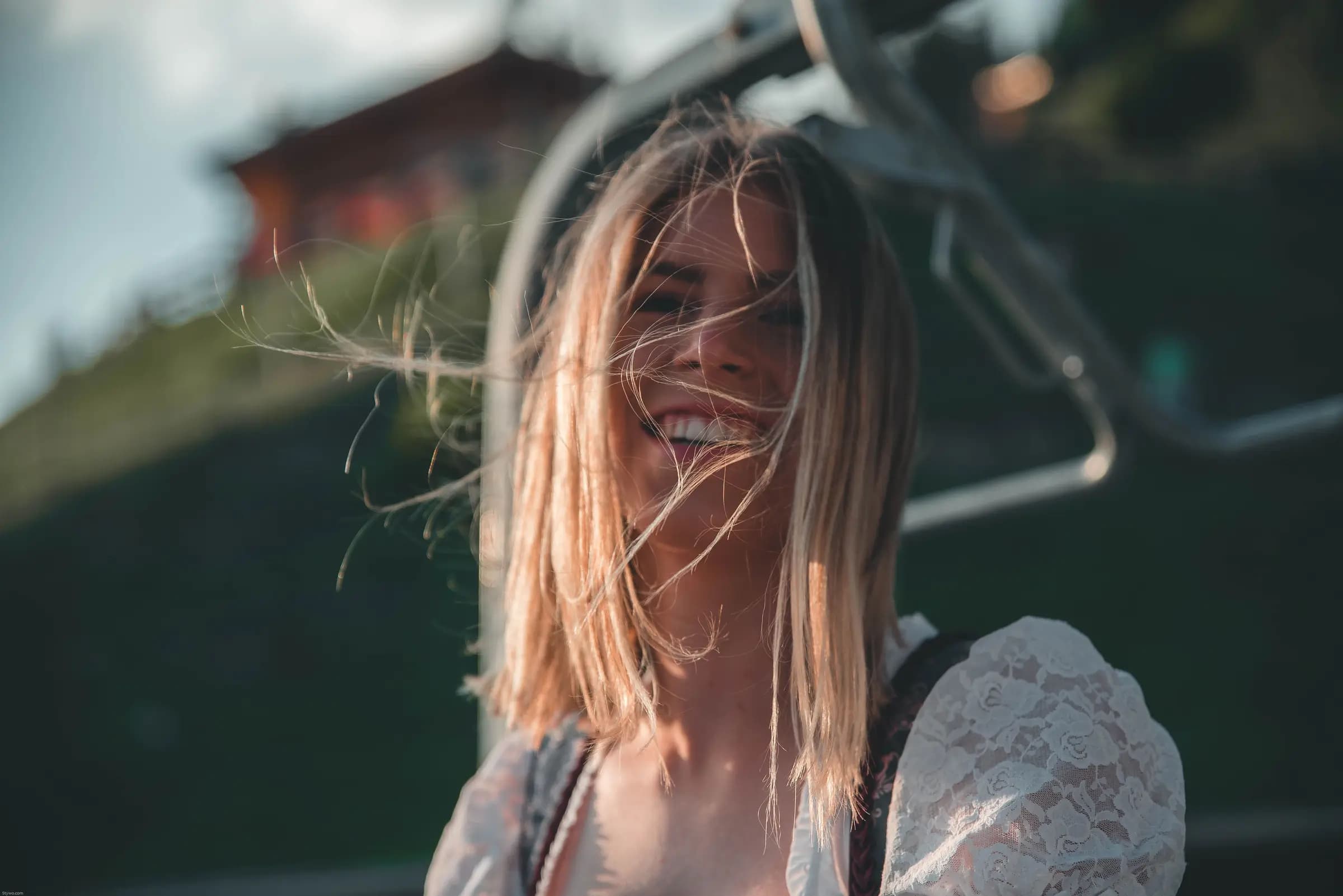 Cheerful woman in dirndl enjoying a sunny day in Kitzbühel, Austria.