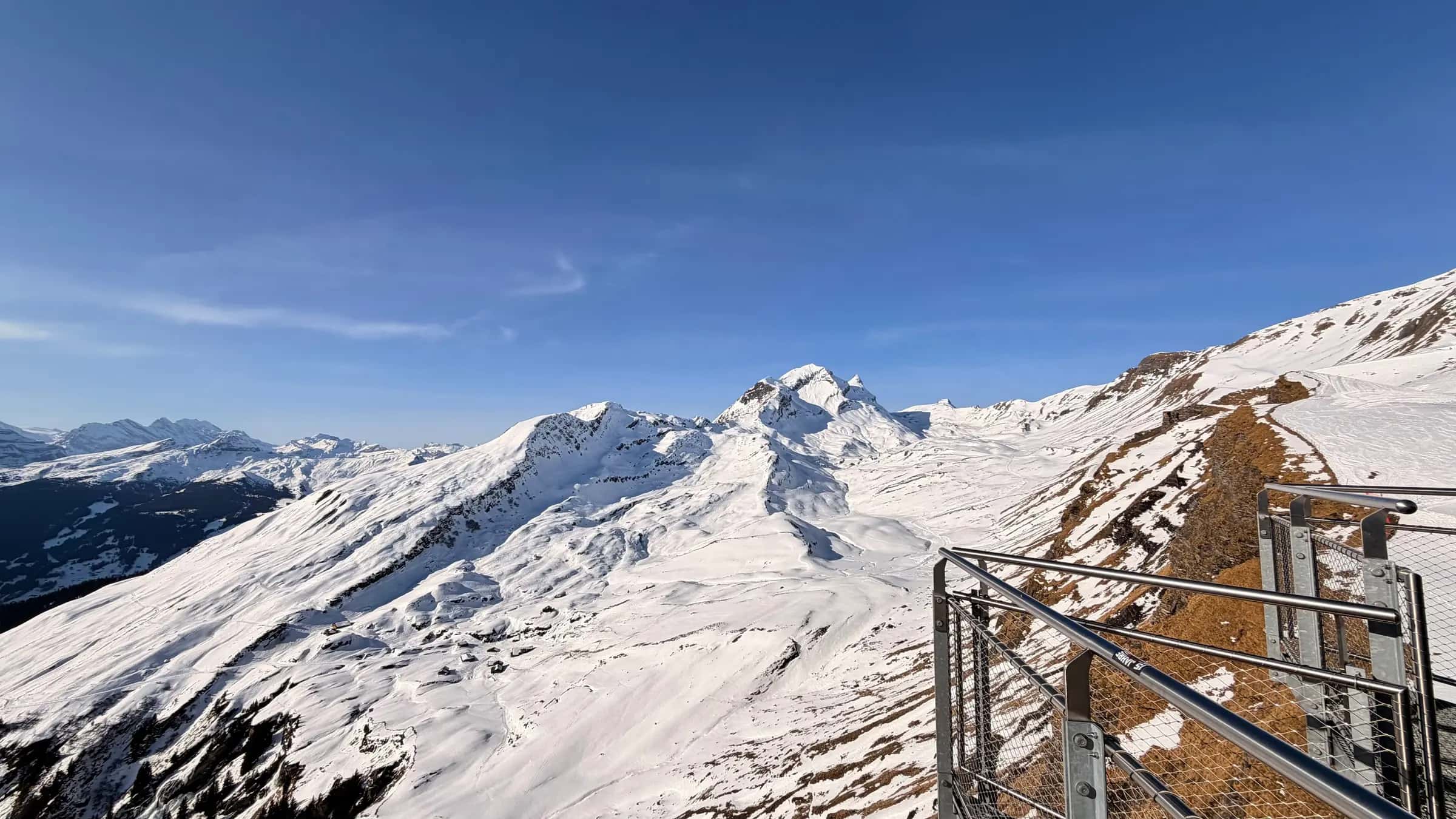 Stunning snowy mountain view from Grindelwald First in Switzerland with clear blue sky.