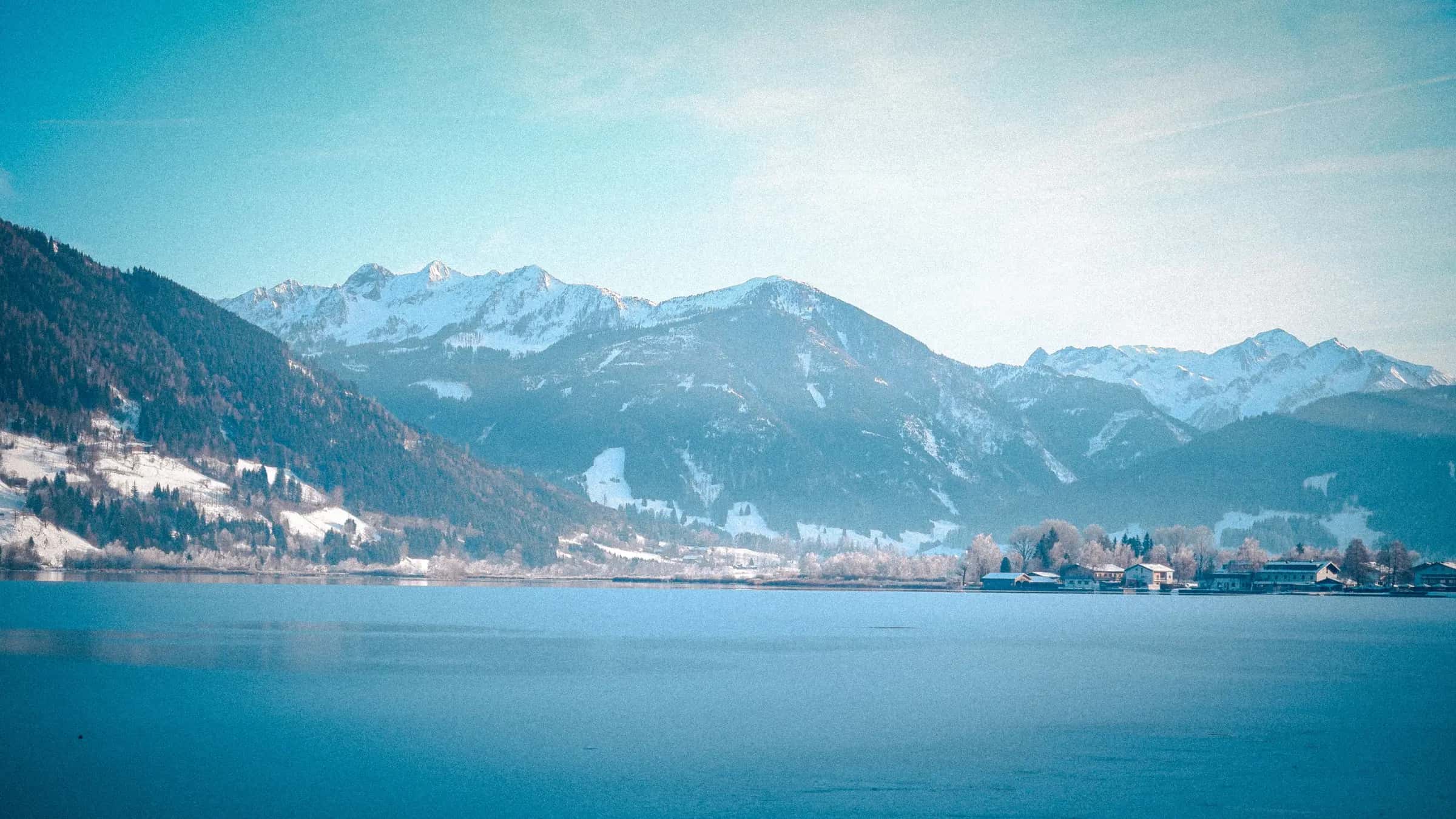 A breathtaking winter view of snow-capped Alps and serene Lake Zell in Zell am See, Austria.