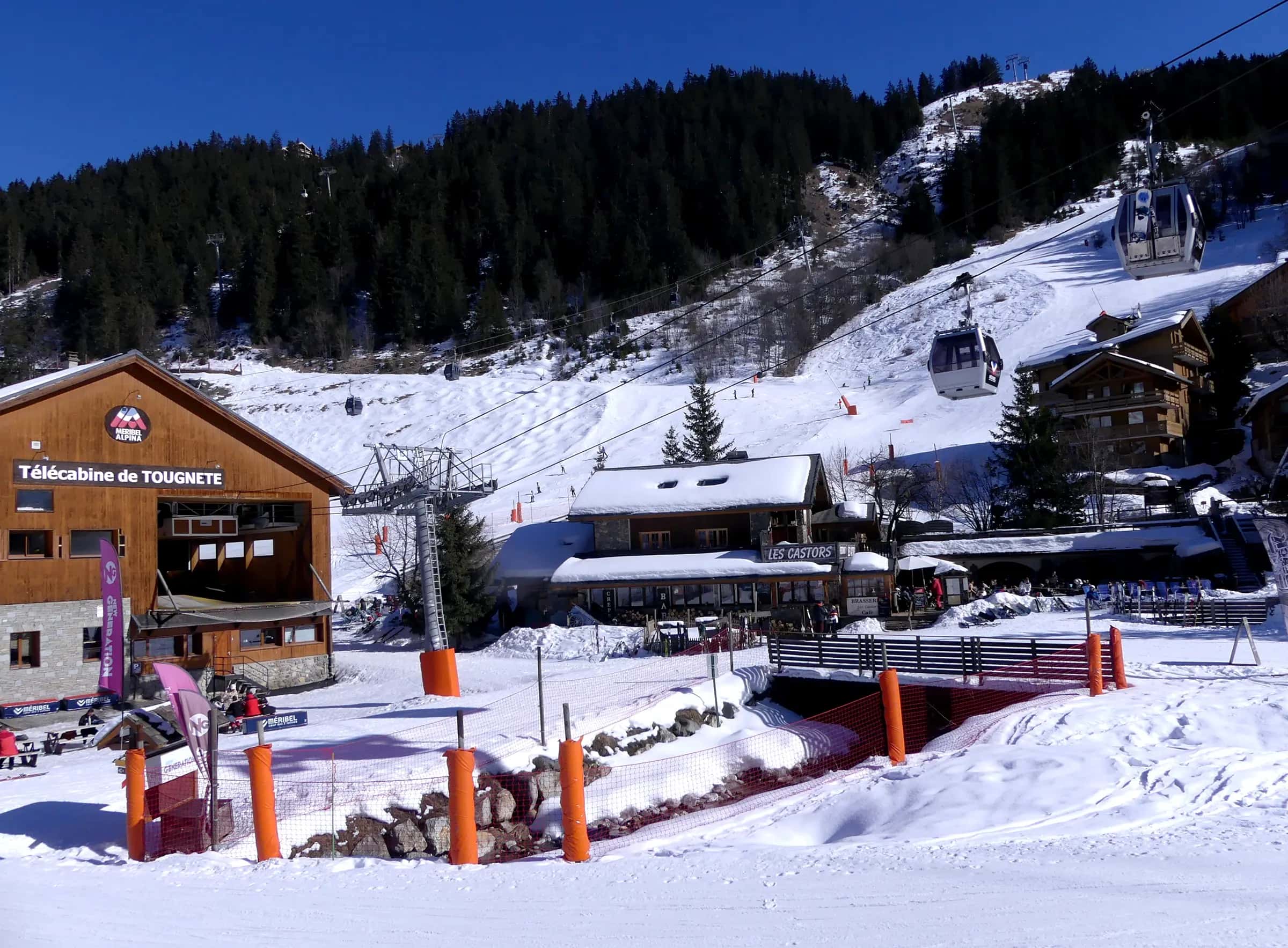 Sight, in winter, of Doron des Allues river and the departure station of Tougnète gondola lift, in Méribel-Centre village and resort, in Savoie , France .
